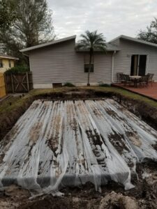 Technician inspecting or servicing a septic tank at a residence as part of an Orlando septic tank service.